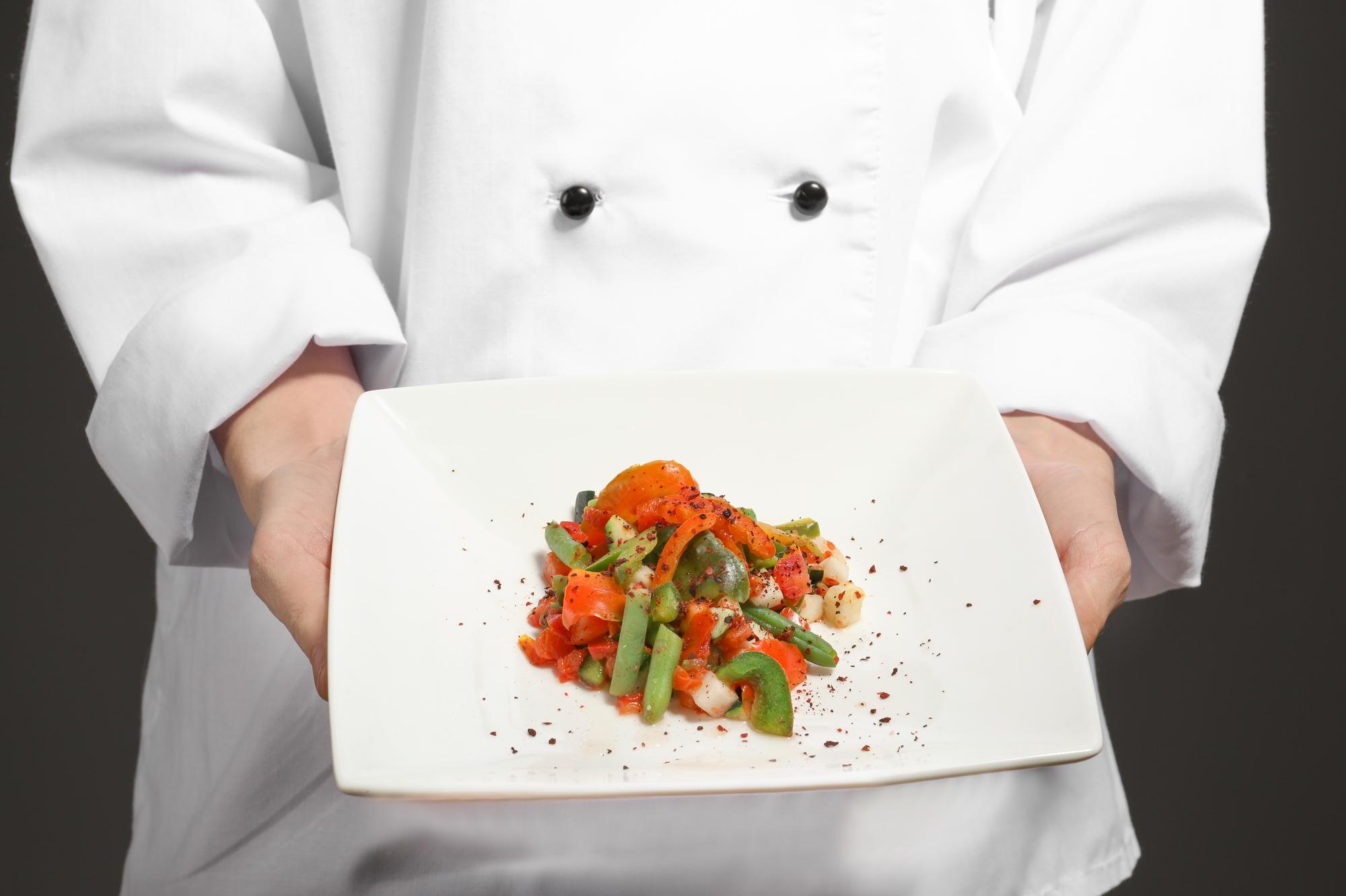 Chef preparando un plato refinado en cocina moderna